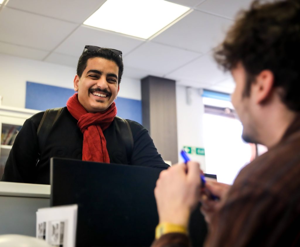 student with reception staff
