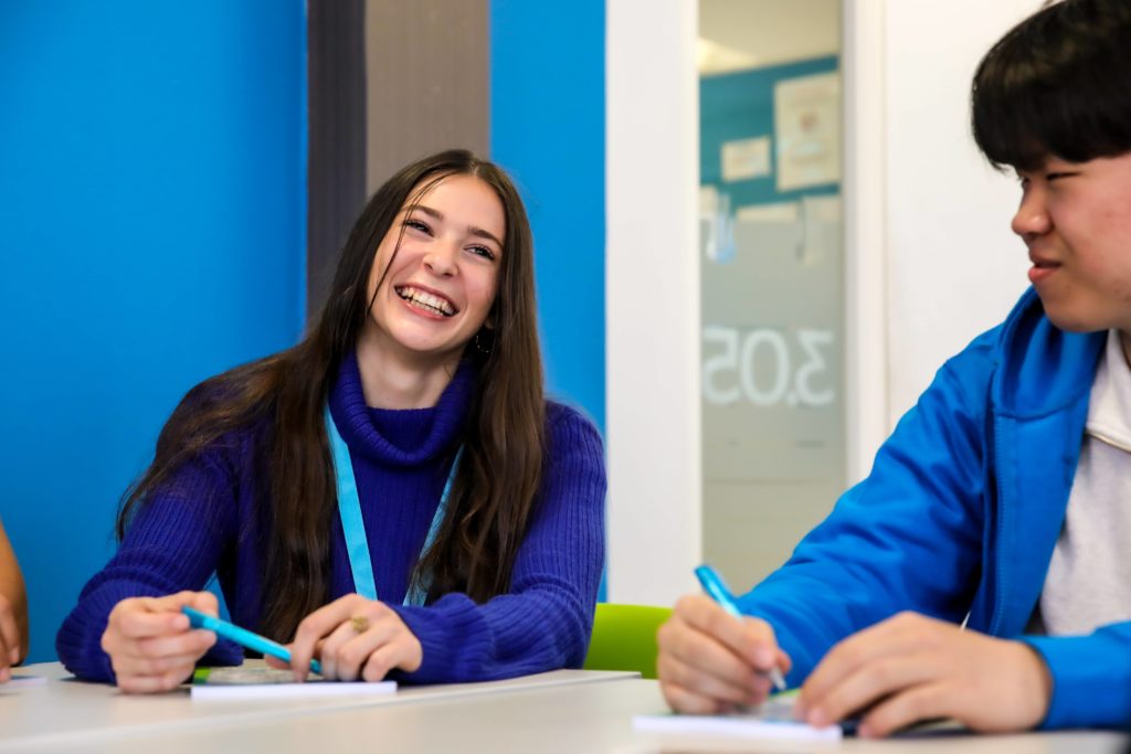 student in a classroom with blue wall in background