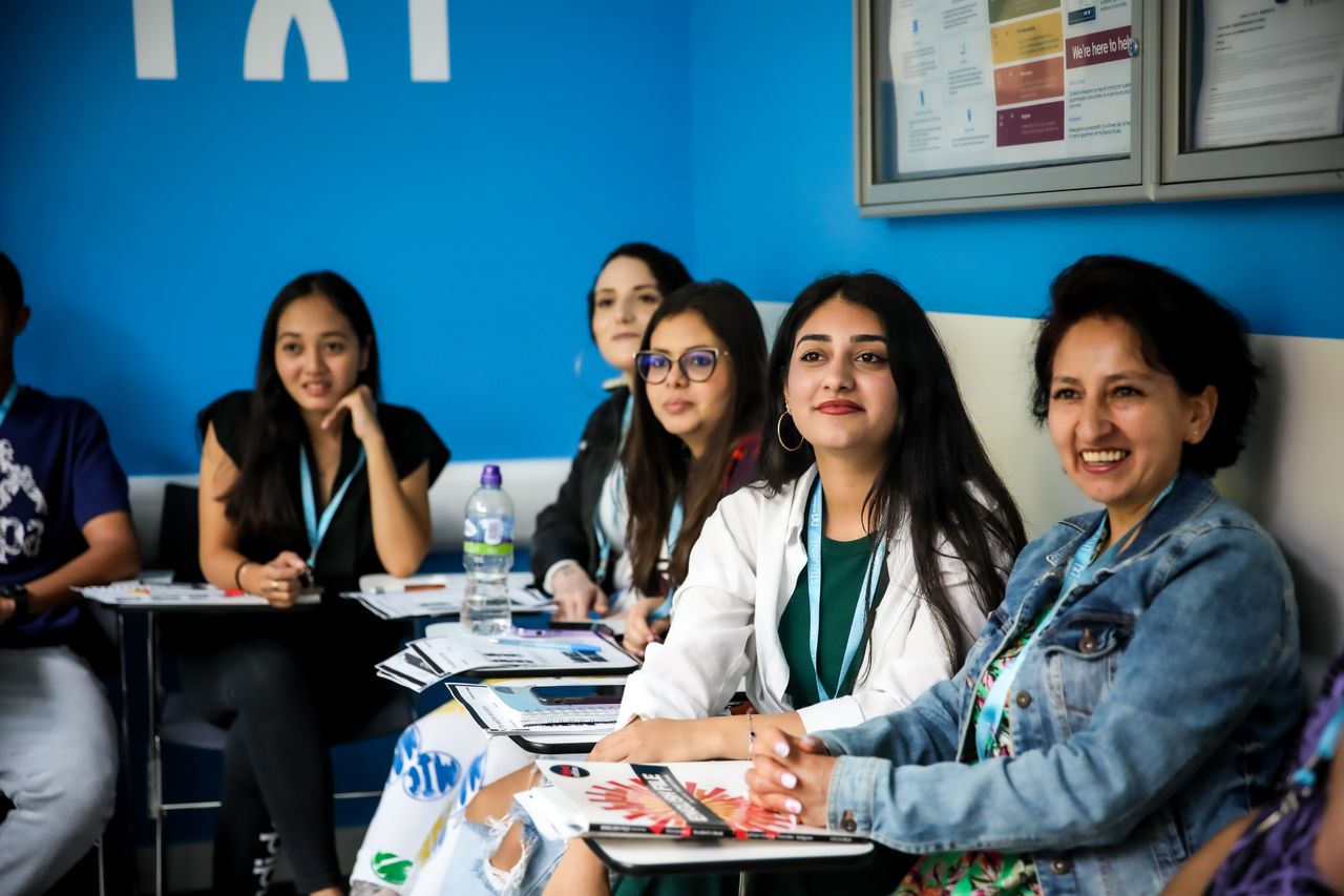 students smiling in classroom with blue background