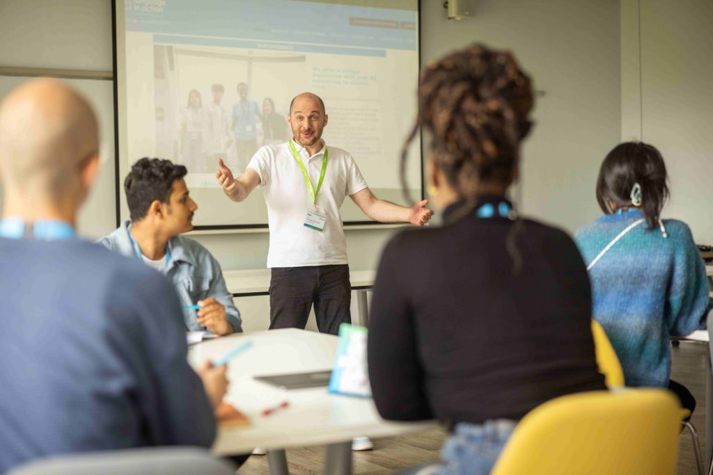 teacher at the front of a classroom teaching